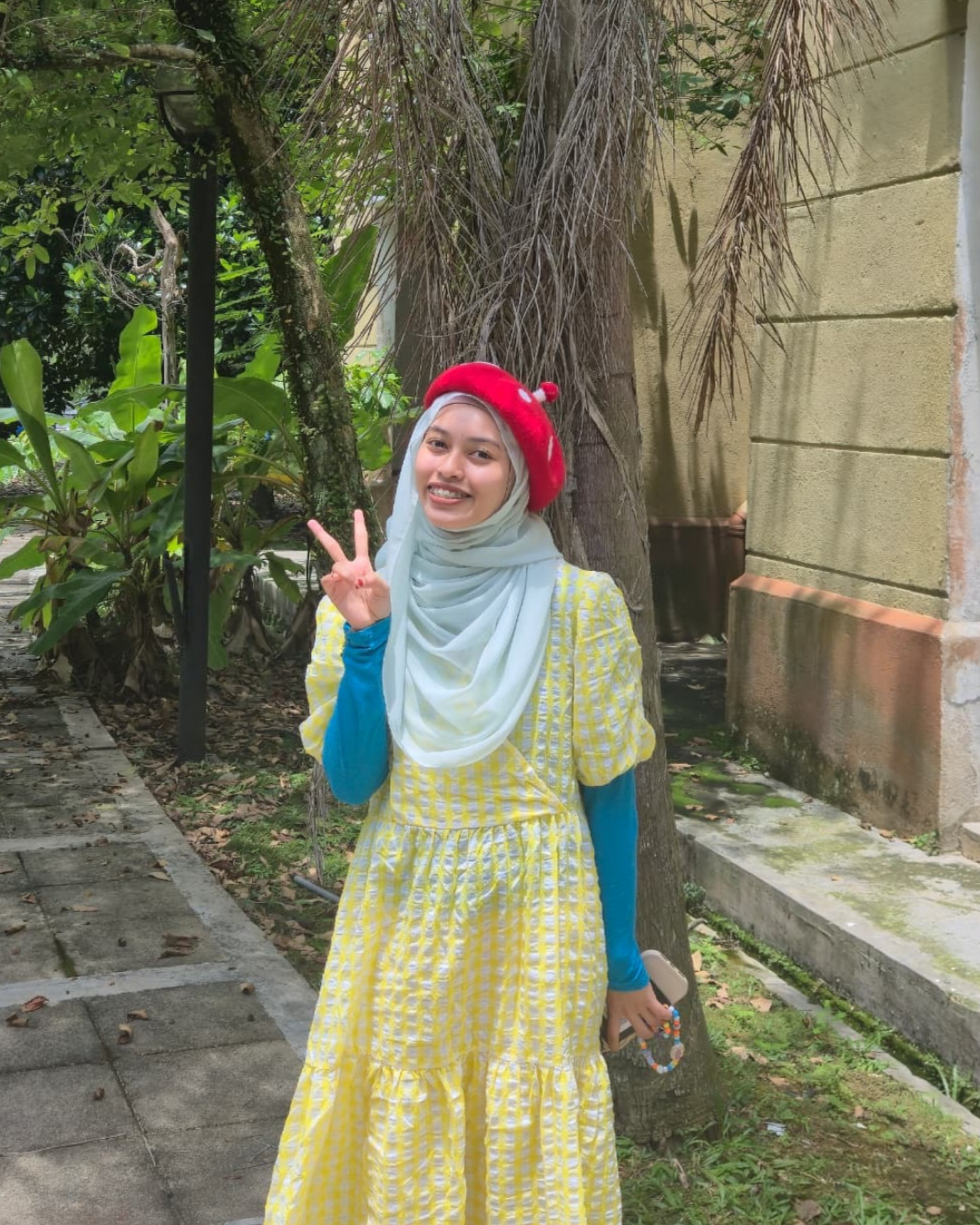 Graduate girl in front of nature smiling