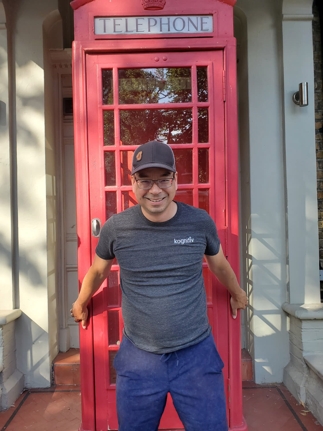 a man in front of a telephone cabin in Wimbledon 