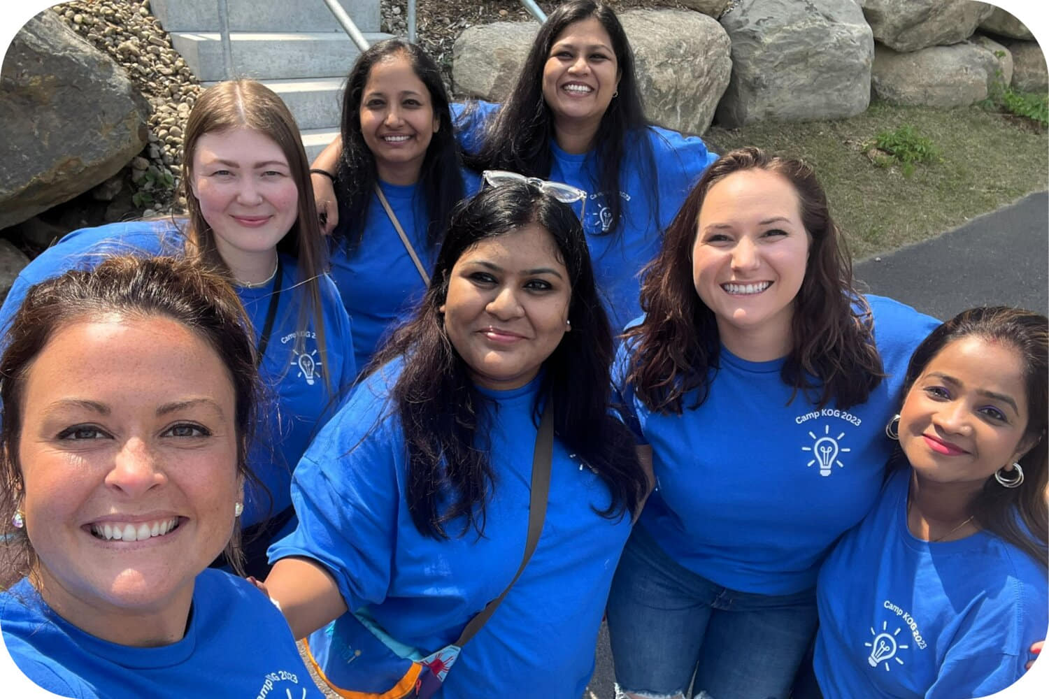 Group selfie of women wearing matching blue shirts