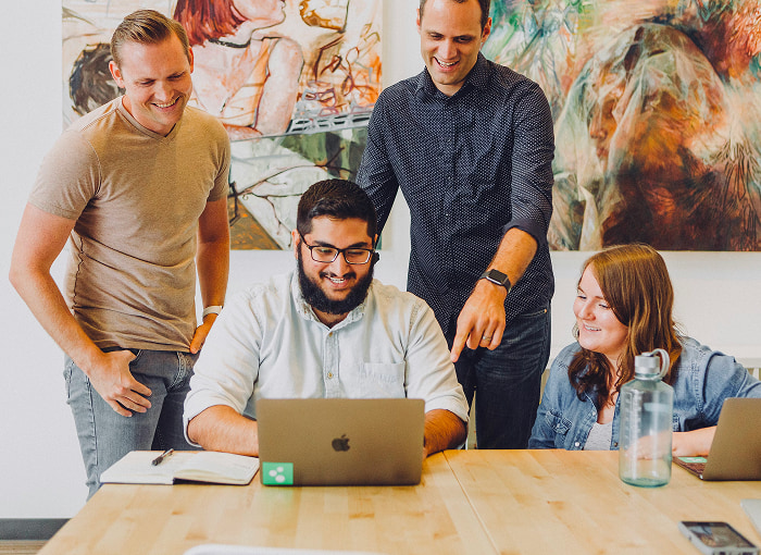 men smiling at the laptop